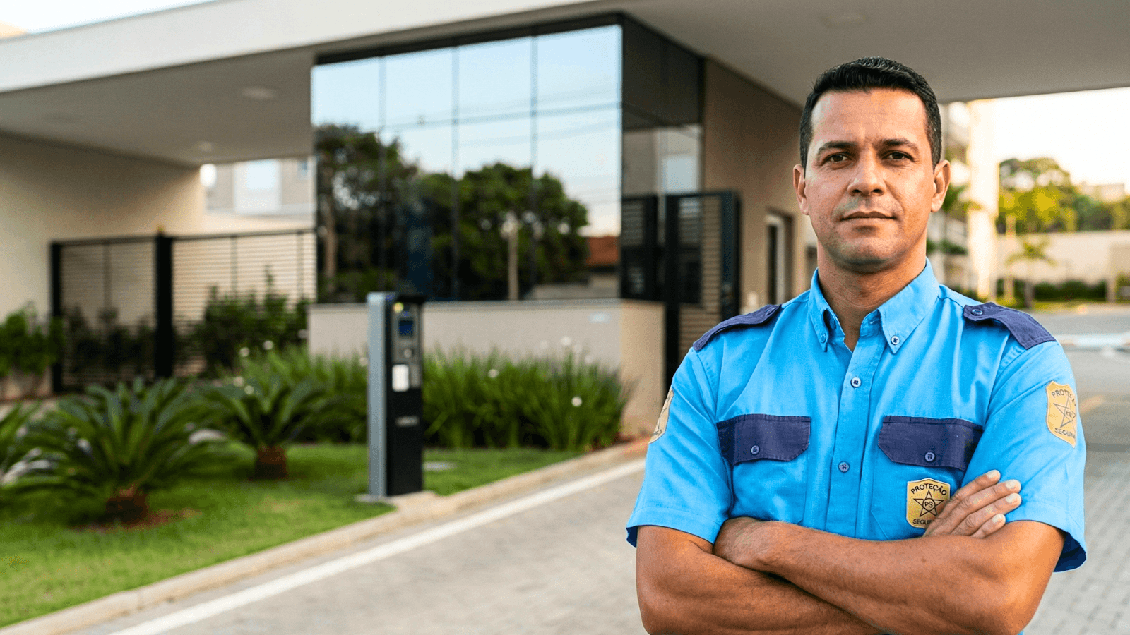 Profissional de segurança da PS Proteção em frente a uma portaria monitorada